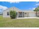 Charming single-story home featuring a screened porch, attached garage, and manicured lawn at 7595 Berwick St, North Port, FL 34287
