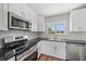 Beautiful kitchen featuring white cabinets, stainless steel appliances, and a sleek range for the home chef at 7595 Berwick St, North Port, FL 34287