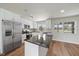 Well-lit kitchen with stainless steel appliances, granite countertops, and a functional island, perfect for modern living at 7595 Berwick St, North Port, FL 34287