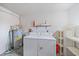 This laundry room has a washer and dryer, water heater, shelving for storage at 7595 Berwick St, North Port, FL 34287