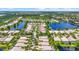Picturesque aerial view of a residential community featuring homes near winding waterways and lush greenery at 7716 Uliva Way, Sarasota, FL 34238