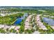Scenic aerial view of a neighborhood featuring homes with pools and solar panels, nestled around a serene lake at 7716 Uliva Way, Sarasota, FL 34238