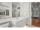 Bright bathroom with large mirror, white double vanity, shower with glass doors, and toilet at 7716 Uliva Way, Sarasota, FL 34238
