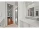 Bright bathroom with large mirror, double vanity, white cabinets, and shower with glass doors at 7716 Uliva Way, Sarasota, FL 34238