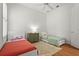 Bedroom with two beds, ceiling fan, wooden floors, and a green cabinet at 7716 Uliva Way, Sarasota, FL 34238