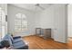 Bright bedroom with wood floors, ceiling fan, arched windows with shutters, and neutral colored crib at 7716 Uliva Way, Sarasota, FL 34238