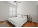 Bedroom with a ceiling fan, wooden floors, white bedding, and shutters at 7716 Uliva Way, Sarasota, FL 34238