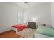 Bedroom with two beds, ceiling fan, wooden floors, and shutters at 7716 Uliva Way, Sarasota, FL 34238