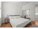 Bedroom with white bedding, ceiling fan, wooden floors, and mirrored closet at 7716 Uliva Way, Sarasota, FL 34238