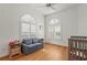Cozy room with wood floors, ceiling fan, arched windows with shutters, and a comfortable blue sofa at 7716 Uliva Way, Sarasota, FL 34238
