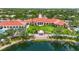 Aerial view of the clubhouse with a clock tower, manicured lawn, and a gazebo overlooking a lake at 7716 Uliva Way, Sarasota, FL 34238