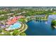 Aerial view of a beautiful community center with a pool, tennis courts, and lakefront scenery at 7716 Uliva Way, Sarasota, FL 34238