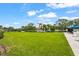 Expansive green lawn with gazebo, lush trees, a pond with fountain, and comfortable seating areas at 7716 Uliva Way, Sarasota, FL 34238