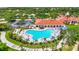 Aerial view of a large clover-shaped pool surrounded by lounge chairs, tables, and lush landscaping at 7716 Uliva Way, Sarasota, FL 34238