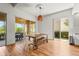 Bright dining area with wood floors, outdoor access, and a natural wood table with chairs at 7716 Uliva Way, Sarasota, FL 34238