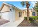 Exterior side view of home showing the garage, landscaped walkway, arched entry, and tropical landscaping at 7716 Uliva Way, Sarasota, FL 34238