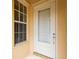 Close-up of a front door with a glass panel, accompanied by a window, showcasing a welcoming entrance at 7716 Uliva Way, Sarasota, FL 34238