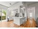 Bright, open kitchen with white cabinets, breakfast bar seating, stainless steel appliances, and hardwood floors at 7716 Uliva Way, Sarasota, FL 34238