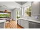 Bright kitchen with wood floors, white cabinets and countertops, stainless steel appliances and natural light at 7716 Uliva Way, Sarasota, FL 34238