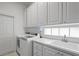 Efficient laundry room with modern appliances, ample cabinet space, and a convenient sink area at 7716 Uliva Way, Sarasota, FL 34238