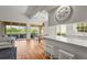 Bright and airy living room with hardwood floors, white walls, and large sliding glass doors leading to a patio at 7716 Uliva Way, Sarasota, FL 34238