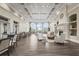 Spacious lounge area featuring hardwood floors, comfortable seating, a fireplace, and large windows at 7716 Uliva Way, Sarasota, FL 34238