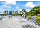 Pool deck featuring lounge chairs and tables, shaded by palm trees and surrounded by lush landscaping at 7716 Uliva Way, Sarasota, FL 34238