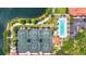 Aerial view of tennis courts, a lap pool, bocce ball court and manicured landscaping near a lake at 7716 Uliva Way, Sarasota, FL 34238