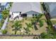 Aerial view of the home featuring a backyard with a patio, shade sail, lush landscaping, and palm trees at 7834 38Th E Ct, Sarasota, FL 34243