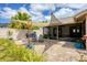Well-maintained backyard featuring a shade sail, brick patio with seating, firepit, and lush landscaping at 7834 38Th E Ct, Sarasota, FL 34243