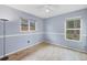 Bright bedroom with blue walls, light wood floors, windows, and a ceiling fan at 7834 38Th E Ct, Sarasota, FL 34243