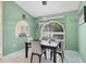Elegant dining room featuring a modern chandelier, arched window, and stylish decor at 7834 38Th E Ct, Sarasota, FL 34243