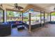 Inviting screened patio with comfortable seating, a TV, ceiling fans, and views of the landscaped backyard at 7834 38Th E Ct, Sarasota, FL 34243