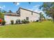 Large backyard with lush green grass, landscaping, and a view of the screened-in patio at 8222 Haven Harbour Way, Bradenton, FL 34212
