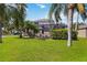 Lush backyard featuring palm trees, green grass, and a screened-in patio, perfect for outdoor enjoyment at 8222 Haven Harbour Way, Bradenton, FL 34212