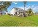 Expansive backyard with lush green grass, mature palm trees, and a screened-in patio at 8222 Haven Harbour Way, Bradenton, FL 34212