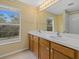 Bright bathroom featuring a double sink vanity, a large mirror, and a window offering natural light at 8222 Haven Harbour Way, Bradenton, FL 34212