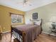 Cozy bedroom featuring a comfortable bed, warm hardwood floors, and a sunny window with decorative curtains at 8222 Haven Harbour Way, Bradenton, FL 34212