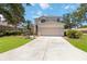 Charming two-story home showcasing a well-manicured lawn, mature trees, and a spacious driveway at 8222 Haven Harbour Way, Bradenton, FL 34212
