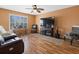 Cozy living room with hardwood floors, ceiling fan, and window letting in natural light at 8222 Haven Harbour Way, Bradenton, FL 34212