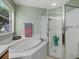 Bright bathroom with a soaking tub, a glass-enclosed shower, and natural light from the window at 8222 Haven Harbour Way, Bradenton, FL 34212