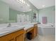 Well-lit bathroom with double sinks, a soaking tub, and a separate glass-enclosed shower at 8222 Haven Harbour Way, Bradenton, FL 34212
