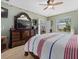 Comfortable main bedroom featuring an ornate dresser, a ceiling fan, and access to the ensuite bathroom at 8222 Haven Harbour Way, Bradenton, FL 34212