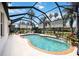 Sparkling pool in a screened enclosure with a waterfall feature and lush landscaping around the patio at 8222 Haven Harbour Way, Bradenton, FL 34212