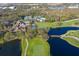 Scenic aerial view of a golf course with a bridge over a pond, lush greens and a community clubhouse at 8706 52Nd E Dr, Bradenton, FL 34211