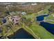 Overhead view of a community golf course featuring a clubhouse, pool, tennis courts, and water features at 8706 52Nd E Dr, Bradenton, FL 34211