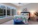 Cozy bedroom with a pool view, bright floral bedding, and comfortable furnishings at 8706 52Nd E Dr, Bradenton, FL 34211