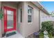 Inviting front entrance with a bright red door and charming decorative accents at 8706 52Nd E Dr, Bradenton, FL 34211