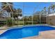 Sparkling pool with a screened enclosure and views of the surrounding golf course and tropical foliage at 8706 52Nd E Dr, Bradenton, FL 34211