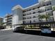 Exterior view of a multi-story residential building with carports, palm trees, and black railings at 8977 Midnight Pass Rd # 521, Sarasota, FL 34242